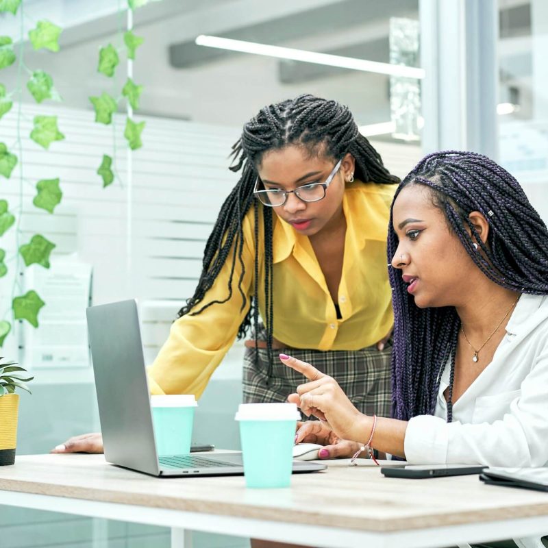 two-young-black-women-reviewing-analytical-data-on-various-electronic-devices-.jpg